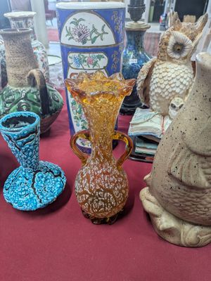 many vases on a table with a red table cloth