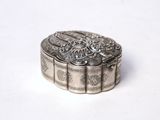 an old silver box sitting on top of a white surface