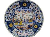 une assiette bleue et blanche avec une image de femme dessus