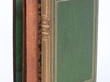 trois livres sont empilés sur une surface blanche