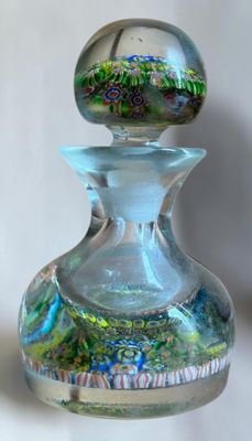 a small glass bottle with a glass top on a table
