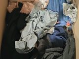 a cardboard box filled with clothes and a teddy bear