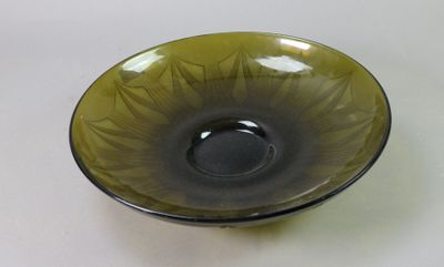 a green bowl with a black rim sitting on a table