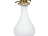 un vase blanc surmonté d'un couvercle doré, posé sur un socle
