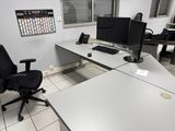un bureau équipé de deux écrans et d'une chaise dans une pièce