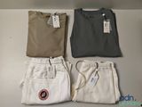 trois paires de pantalons pour homme et un t-shirt posés sur une table