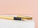 a close up of a fountain pen sitting on top of a marble block