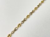 a close up of a gold chain on a white surface