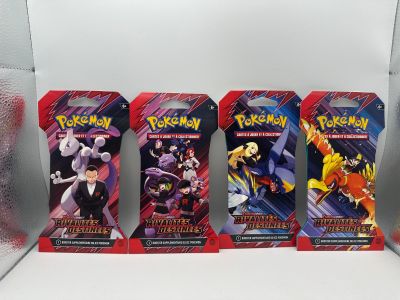 trois paquets de cartes à collectionner Pokémon exposés dans une vitrine