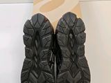 the pair of black shoes are next to a cardboard box