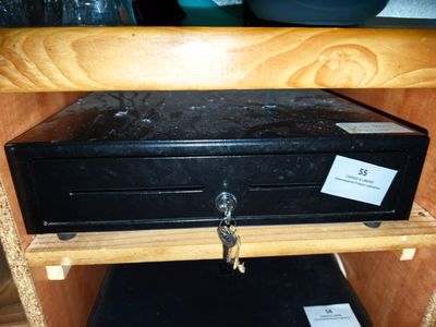 une boîte métallique noire sur laquelle repose une clé