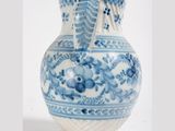 a blue and white vase sitting on a white surface