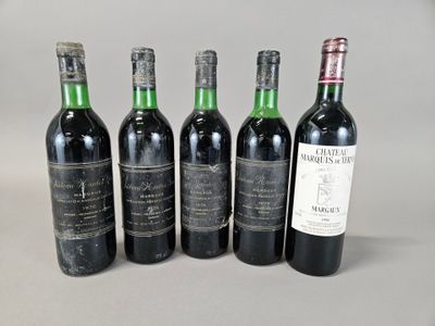 quatre bouteilles de vin sont alignées sur une table