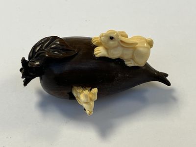 NETSUKE en bois en forme de fruit dévoré par deux petits lapins. 