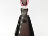 a glass vase with a pink top on a white surface