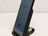 a close up of a cell phone on a stand on a white surface