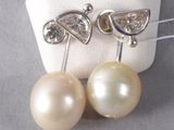 pair of pearl and diamond earrings on display on white cloth