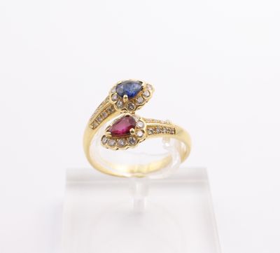 a close up of a yellow gold ring with a blue and red stone