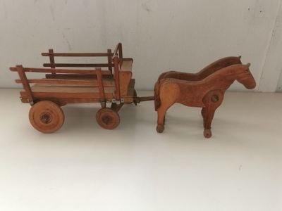 pair of wooden toy horses pulling a wagon with a wooden horse