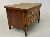 a small wooden table with three drawers on top of it