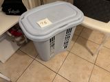 a trash can sitting on a tiled floor in a bathroom