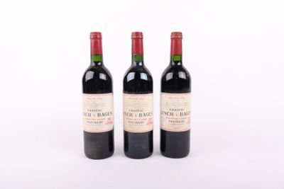 trois bouteilles de vin rouge posées l'une à côté de l'autre sur une surface blanche