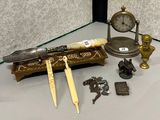 une vitrine en verre sur laquelle sont posés une horloge, un couteau et d'autres objets