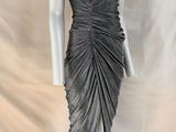 un mannequin vêtu d'une robe grise sur un présentoir blanc