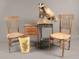 three wooden chairs and a table with a vase on top of it