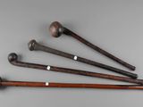 four old baseball bats are lined up on a table