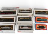 tout un tas de trains miniatures différents, rangés dans des boîtes sur la table