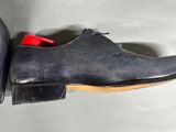 a close up of a pair of black shoes with red soles