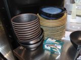 a lot of plates and bowls sitting on the counter