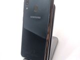 a black samsung phone that is sitting on top of a stand
