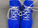 pair of blue boots with white laces on a gray surface