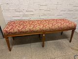 un banc recouvert d'un tissu à motifs floraux rouges et jaunes
