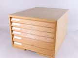 une petite boîte en bois munie de quatre tiroirs