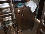 une petite cuisine équipée d'un meuble en inox et d'étagères