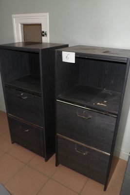 deux commodes noires placées l'une à côté de l'autre dans une pièce