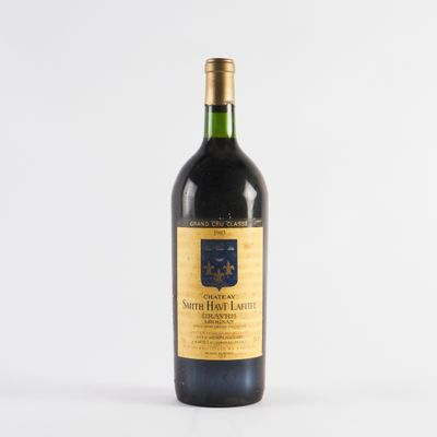 une bouteille de vin posée sur une table blanche