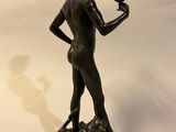 bronze statue of a woman holding a bird in her hand