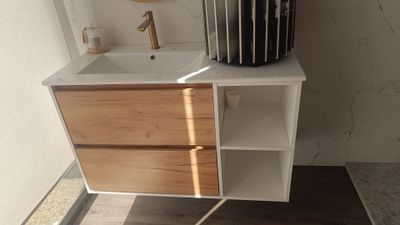 un lavabo blanc et un meuble de salle de bains en bois