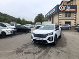 une voiture blanche garée devant un bâtiment dans un parking