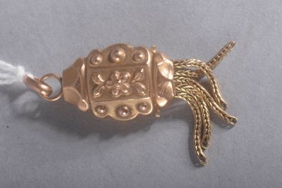 a gold colored brooch with a tassel on it
