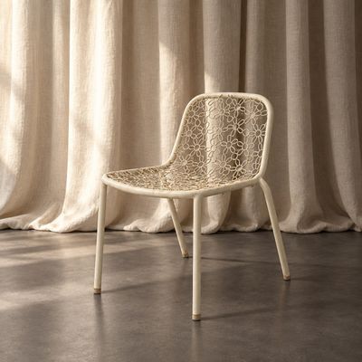 une chaise blanche posée devant un rideau