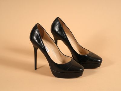 des escarpins noirs à talons hauts sur un fond beige