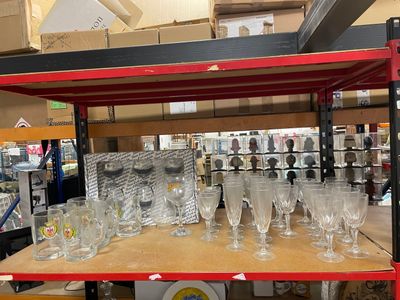 many empty wine glasses on a shelf in a store