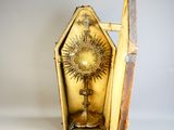 a small box with a gold sunburst inside of it