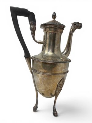 an antique silver tea pot with a handle on a stand