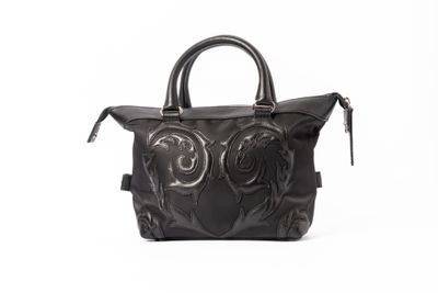 sac à main en cuir noir sur fond blanc, avec un fond blanc